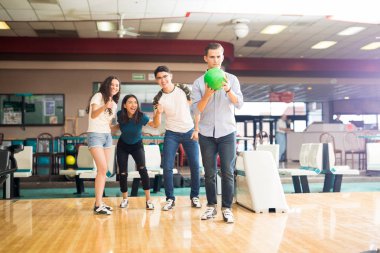 Genç çocuk kulübü sokakta, tezahürat arkadaş süre bowling topu atma 