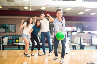 Genç çocuk kulübü sokakta, tezahürat arkadaş süre bowling topu atma 