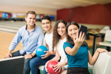 Cep telefonu bowling Club üzerinde arkadaşlarınızla selfie alarak gülümseyen genç kız