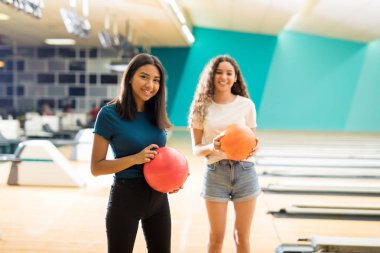 Gülümseyen genç kız arkadaşıyla bowling salonu kulüp ayakta
