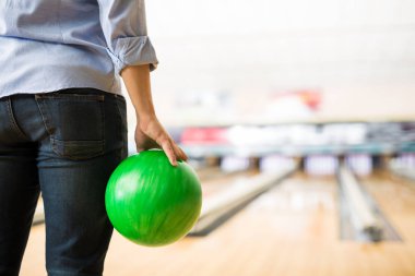 Genç çocuk Bowling Club yeşil topu ile pratik