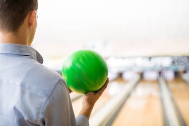 Arkadan Görünüş yeşil bowling topu kulüp ile oynayan genç