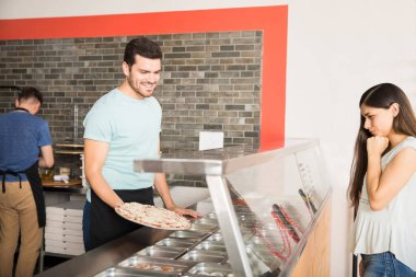 Gülümseyen yakışıklı Şef taze tutan müşteri ilave Topingler seçmek yardım pizza pişmiş