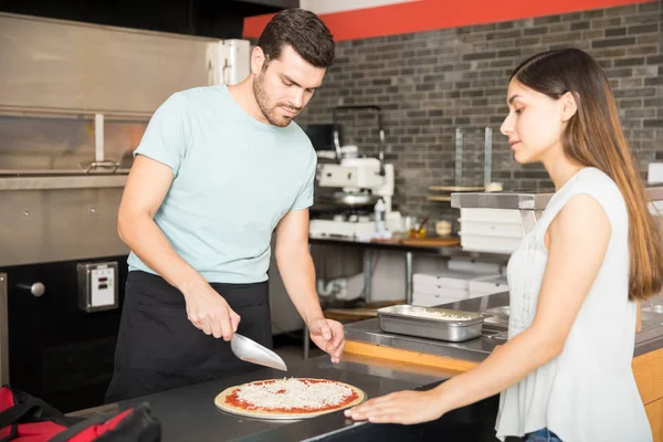 Şef Mutfak Tezgahı Pizzacı Pizza Ayakta Rendelenmiş Peynir Eklemek Odaklı — Stok fotoğraf