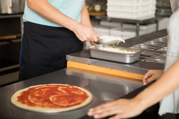 Närbild Kock Händer Lägga Riven Ost Pizza Med Röda Tomatpuré — Stockfoto