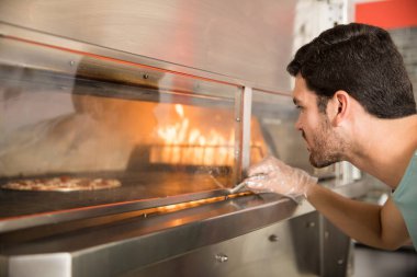 Yakışıklı Şef pizza üzerinde kontrol fırın kolu elinde eldiven giymiş portresi
