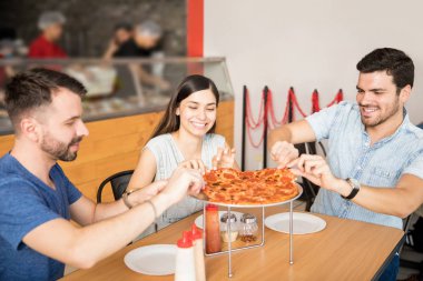 İki yakışıklı adamla neşeli güzel kadının pizza dilimleri kadar toplama süre restoranda parti