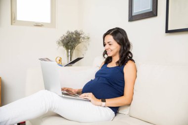 Oldukça hamile kadının dizüstü onu serbest zaman sırasında evde kullanma