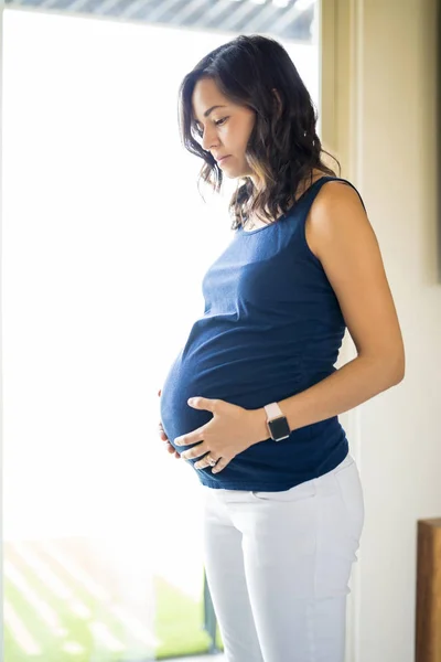 Mid Volwassen Zwangere Vrouw Dagdromen Door Raam Thuis — Stockfoto