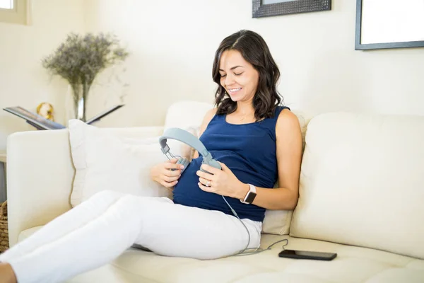 Content Pregnant Female Headphones Tummy Sitting Sofa Home — Stock Photo, Image