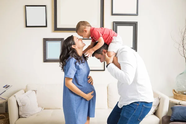 Sonriente Mujer Embarazada Llevando Hijo Mientras Está Pie Por Hombre — Foto de Stock