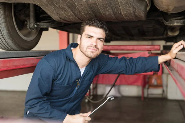 Handsome Mecânico Segurando Chave Inglesa Sob Carro Oficina Reparação Automóveis — Fotografia de Stock