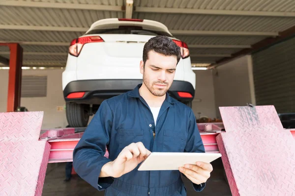 Mittlerer Erwachsener Automechaniker Surft Auf Digitalem Tablet Mit Hydrauliklift Hintergrund — Stockfoto