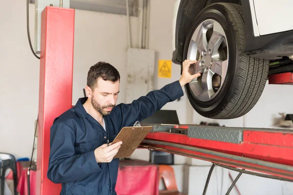 Mid Adult Automobile Engineer Examining Car Tire While Going Checklist — Stock Photo, Image