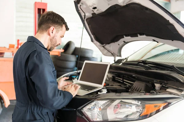 Mediados Adulto Trabajador Reparación Automóviles Utilizando Portátil Para Detectar Mal —  Fotos de Stock