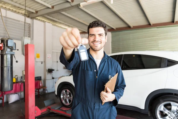 Portrait Smiling Male Mechanic Giving Car Key While Standing Auto — Stock Photo, Image