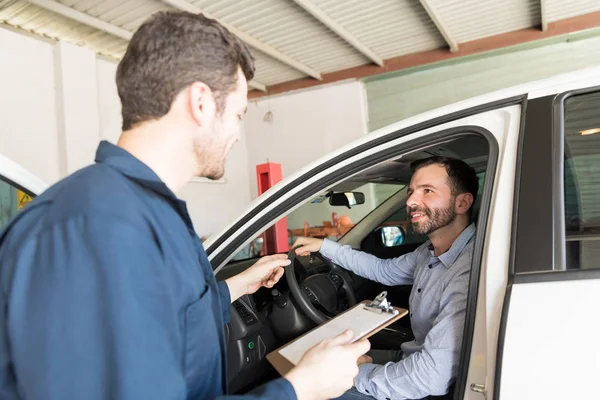 Serwis Man Przytrzymanie Schowka Podczas Rozmowy Klientem Samochód Warsztat Samochodowy — Zdjęcie stockowe