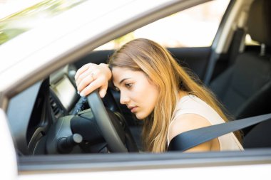Araba direksiyon simidinde ağır trafik sıkışıklığı sırasında Uyuyan Genç beyaz kadın