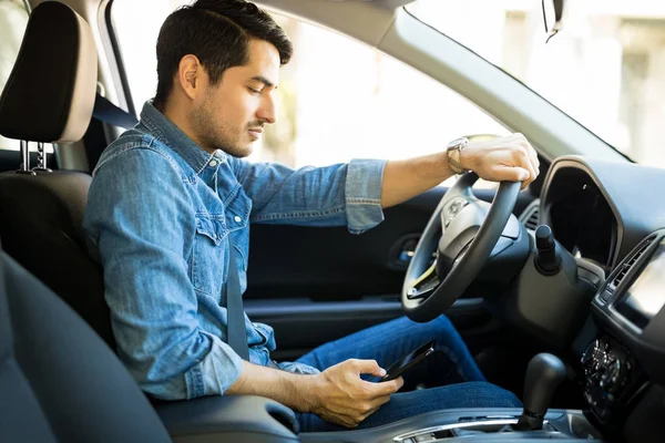 Vista Lateral Homem Latino Dirigindo Carro Lendo Mensagem Texto Seu — Fotografia de Stock