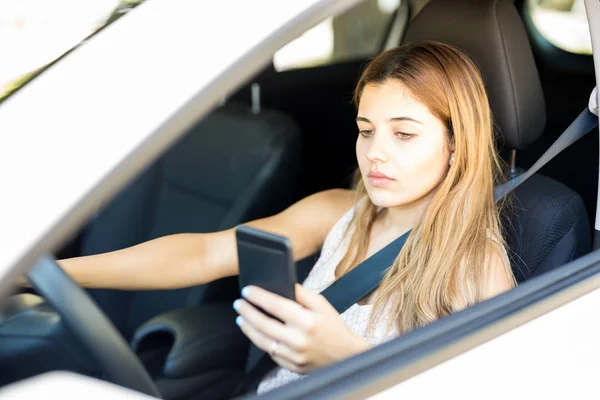 Piękna Kobieta Jazdy Samochodu Czytanie Wiadomości Sms Jej Telefon Komórkowy — Zdjęcie stockowe