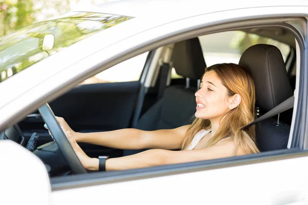 Angry female driver honking the car horn in traffic jam