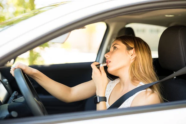 美しい女性は車を運転 口紅を適用して渋滞中に電話で話して — ストック写真