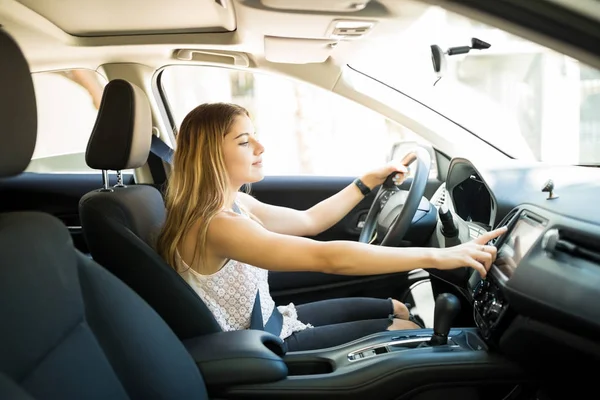 車を運転して タッチ スクリーン マルチ メディア パネルを使用して ダッシュ ボード上の美しい若い女性の側面の肖像画 — ストック写真