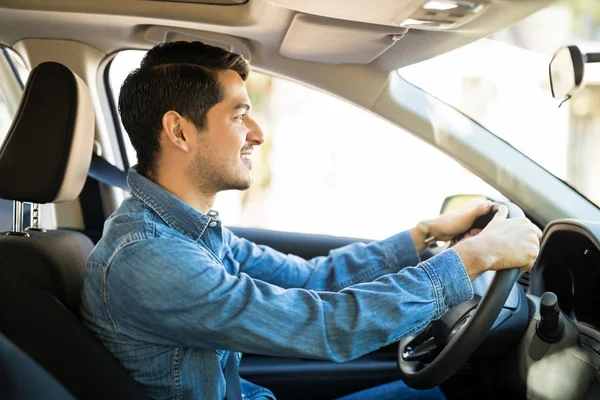 外形视图一个好看的年轻人开着车 注意路 人戴着安全带 双手放在方向盘上 理想的驾驶条件 — 图库照片