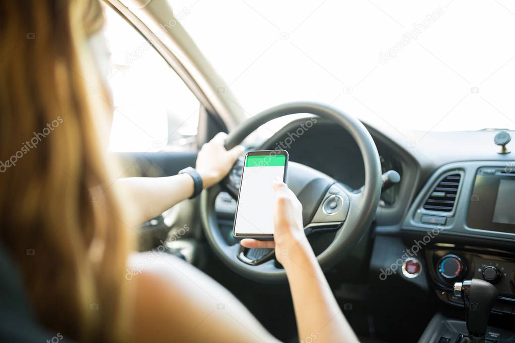 Hand of female driver using maps on smartphone to find the right place to go