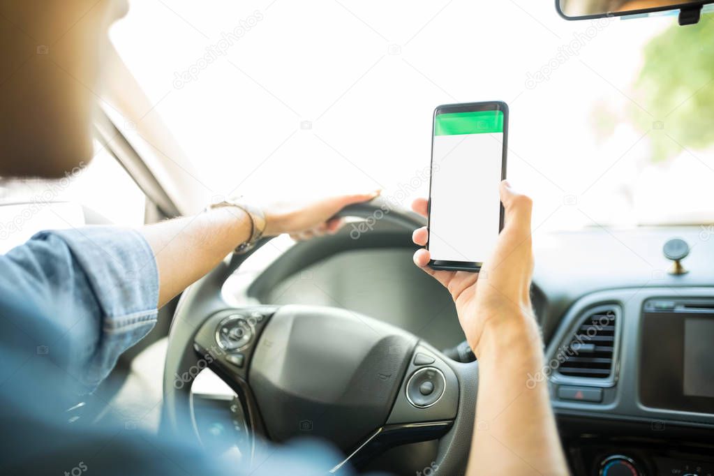 Hand of man driver using GPS navigator on his smartphone to find the shortest route to reach the destination