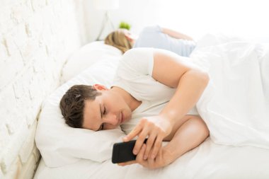 Yetişkin kız evde yatakta tarafından yalan sırasında cep telefonu kullanan adam dağıttı