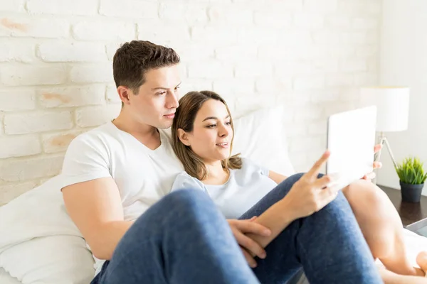 男性和女性坐在家里的床上自拍在数字平板上 — 图库照片