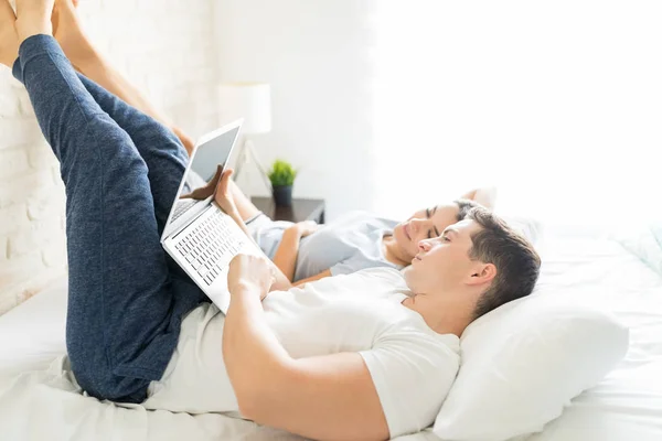 Mid Volwassen Man Met Laptop Liggend Door Jonge Vrouw Bed — Stockfoto