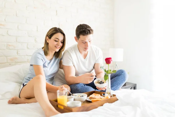 男と女のアパートでベッドの上に座りながら健康的な朝食を食べること — ストック写真