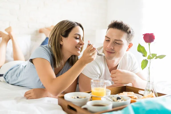 Vacker Ung Kvinna Utfodring Pojkvän Frukost Sängen Hemma — Stockfoto