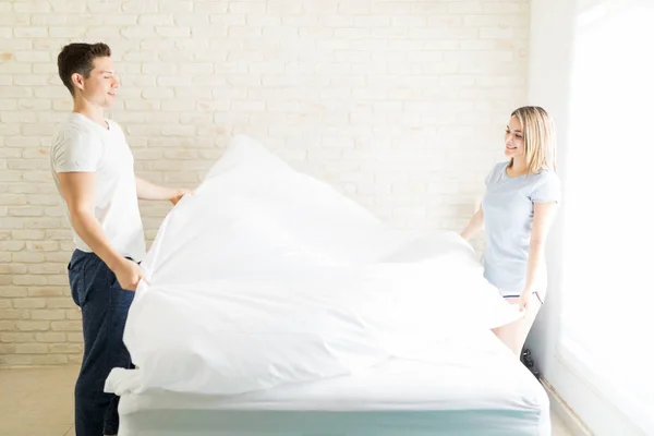 情侣在公寓床上安排白色亚麻布 — 图库照片