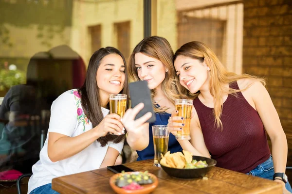 Três Jovens Mulheres Sentadas Restaurante Com Cervejas Tirando Selfie Com — Fotografia de Stock