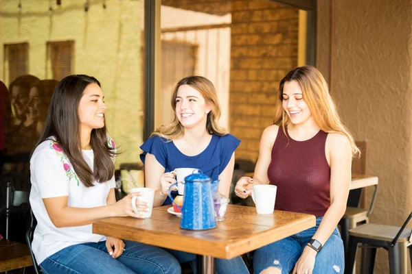 三年轻妇女笑在餐馆与咖啡 — 图库照片