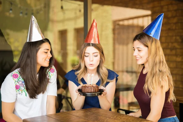 Kobieta Dmuchanie Tort Urodzinowy Świece Przyjaciółmi Przy Ognisku Lub Restauracji — Zdjęcie stockowe