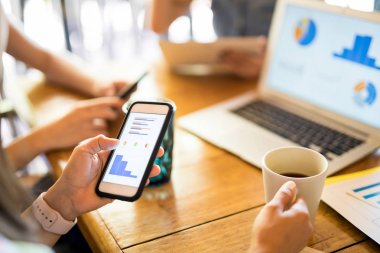 Bazı çizelgeleri cep telefonunu arayan genç kadın 