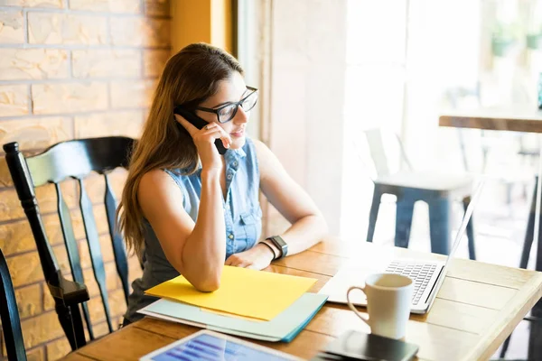 Портрет Молодой Женщины Сидящей Кафе Смотрящей Ноутбук Разговаривающей Мобильному Телефону — стоковое фото