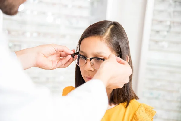 Manos Optometrista Ayudando Niña Pequeña Probar Nuevos Espectáculos Tienda Óptica — Foto de Stock