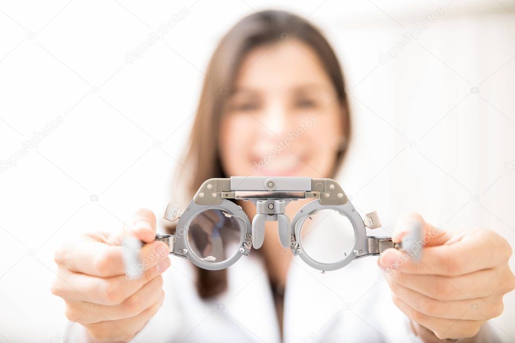 Close-up of optometrist holding glasses in ophthalmology clinic
