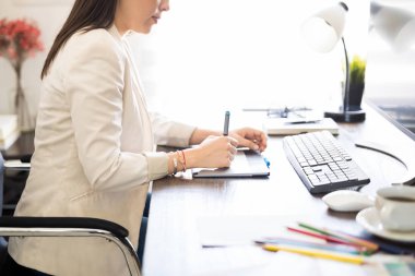 Kadın fotoğraf retoucher iş grafik tableti kullanarak yan görünüm