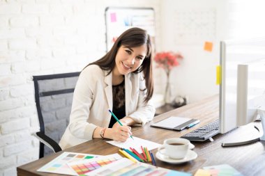 Kağıt üzerinde bazı çizimler yapma ve göz teması yapım onun ofis masası, yaratıcı kadın oturma portre