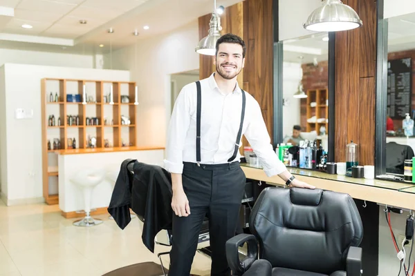 Retrato Peluquero Varón Confiado Sonriendo Mientras Está Pie Junto Silla —  Fotos de Stock