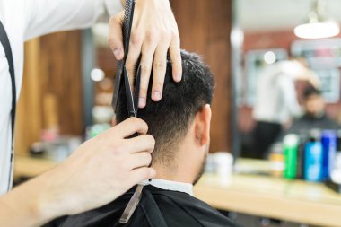 Salon de müşterinin saç kesmek için makas kullanarak erkek uzman eller closeup