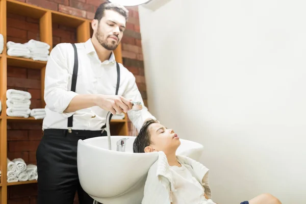 专业美发师在理发店洗涤客户的头发 — 图库照片