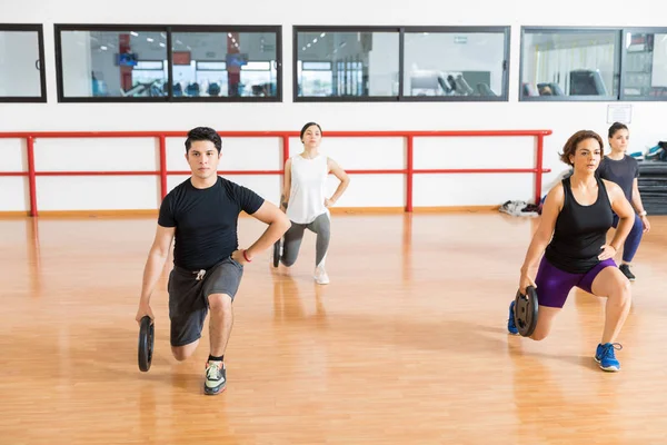 Spor Salonunda Lunges Yaparken Ağırlık Tutan Erkek Dişi Istemcileri — Stok fotoğraf