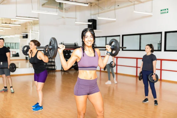 Selbstbewusste Sportliche Frau Trägt Langhantel Auf Schultern Während Freundinnen Fitnessstudio — Stockfoto